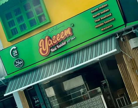 The green Yaseem Nasi Kandar signboard at 508 MacPherson Road, with its round 24 HOURS badge, halal badge and the cuisine strip listing South Indian, North Indian, Thai Seafood, Middle Eastern and Western